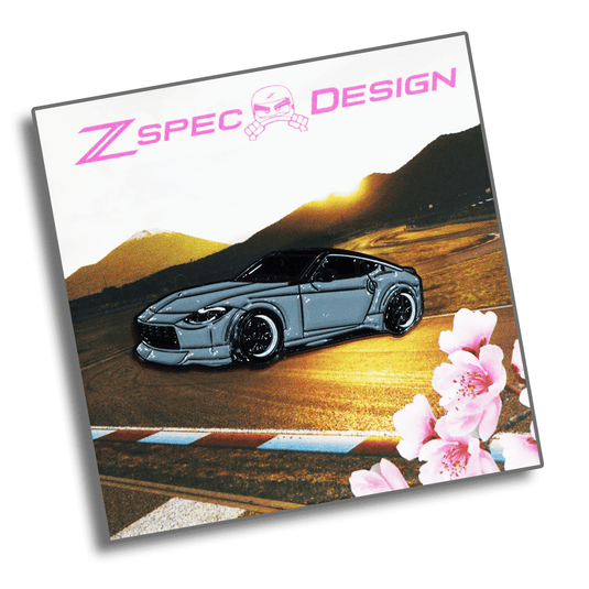 Grey Nissan Z (RZ34) enamel collector pin by ZSPEC Design displayed on branded card art with cherry blossoms.
