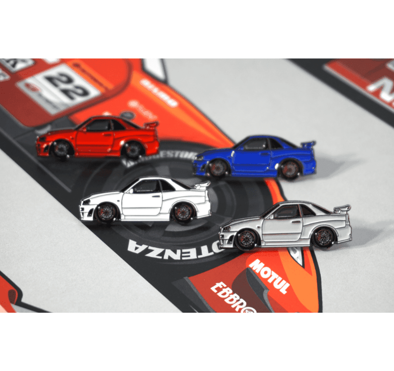 Load image into Gallery viewer, ZSPEC hat pins of red, blue, white, and silver Nissan Skyline GT-R R34 models on a branded background.
