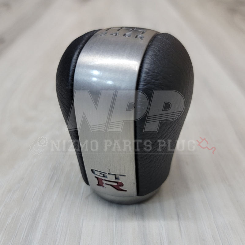 Load image into Gallery viewer, Black and silver 6-speed shift knob for Nissan R34 Skyline GT-R Series 2 with GT-R logo.
