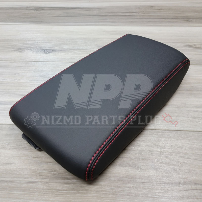 Load image into Gallery viewer, Black leather console lid for Nissan Skyline GT-R with red stitching on a light wood background.
