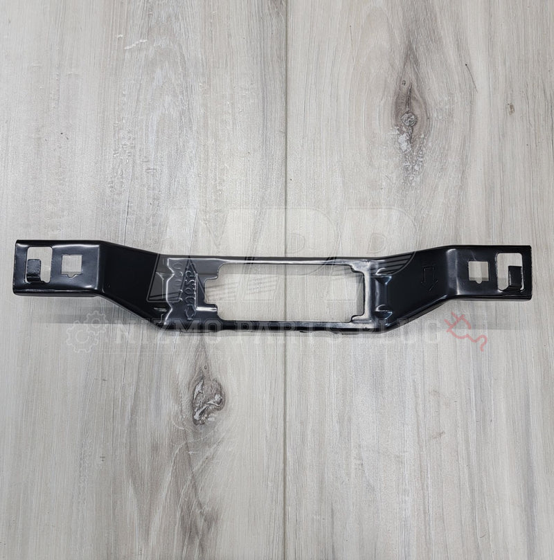 Load image into Gallery viewer, New black license plate lamp bracket for R34 Nissan Skyline on a light wood grain surface.
