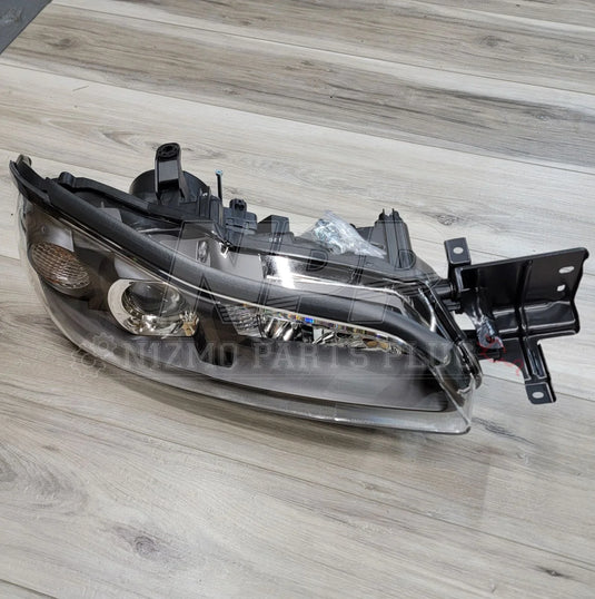 Nissan S15 Silvia HID RH Projector Headlight Assembly on a wooden surface.