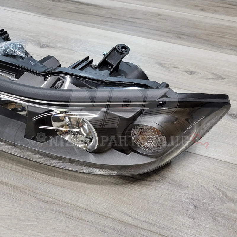 Load image into Gallery viewer, Nissan S15 Silvia HID LH Projector Headlight Assembly on wooden background, showcasing genuine OEM quality.
