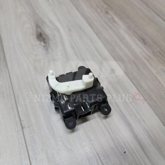 Black and white Nissan S14 Silvia/Stagea A/C air mix door actuator on a wood background.